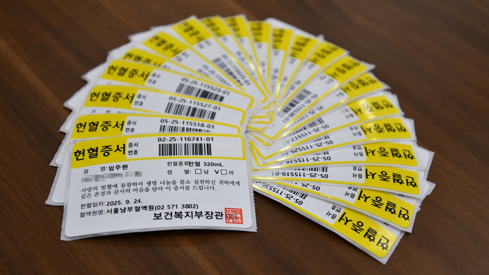 <사진> 한미그룹 임직원들이 헌혈을 통해 모은 헌혈증서들. 헌혈증서에 한미그룹 창업주 임성기 회장의 장녀 임주현 부회장의 헌혈증서도 보인다.